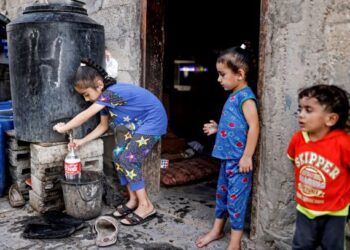 KANAK-KANAK perempuan Palestin mengisi air ke dalam botol di kawasan kejiranan Khan Yunis yang daif di Semenanjung Gaza. - AFP