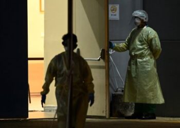 PETUGAS perubatan mengenakan sut perlindungan diri ketika menunggu pesakit di sebuah hospital di Singapura. - AFP