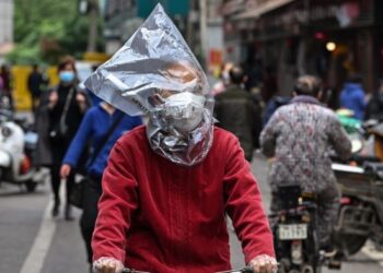 SEORANG lelaki membungkus kepalanya dengan plastik bagi mengelak dijangkiti Covid-19 di Wuhan, China pada tahun lalu. – AFP