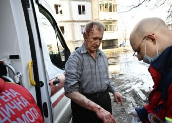 PETUGAS kecemasan membantu seorang lelaki yang tercedera selepas bandar Chuhuiv di timur Ukraine diserang bom tentera Rusia.-AFP