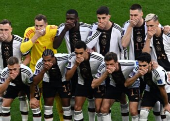 Pemain Jerman menutup mulut ketika sesi bergambar sebelum memulakan perlawanan menentang Jepun di Stadium Antarabangsa Khalifa (AFP)