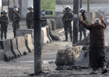 SEORANG lelaki warga emas Palestin mengangkat tangan di depan tentera Israel yang mengacukan senjata ke arahnya di Ramallah, Tebing Barat. - AFP