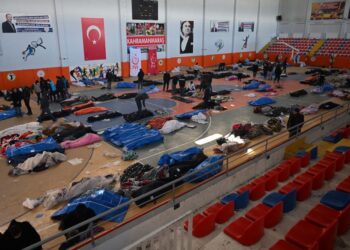 ORANG ramai melintasi kawasan di mana mayat-mayat mangsa gempa bumi disimpan di Dewan Sukan Bandar Kahramanmaras, Turkiye. -AFP