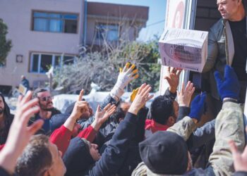 PENDUDUK mengambil makanan, pakaian dan barangan rumah yang dihantar dari belakang trak di Samandag, selatan Hatay. -AFP