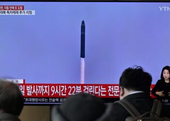 ORANG ramai duduk berhampiran televisyen yang menyiark berita dengan rakaman fail ujian peluru berpandu Korea Utara, di stesen kereta api Seoul. -AFP
