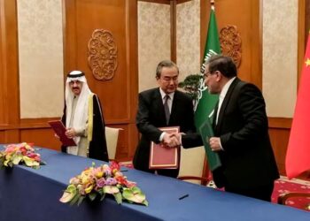(DARI kanan) Setiausaha Majlis Keselamatan Kebangsaan Tertinggi Iran, Ali Shamkhani berjabat tangan dengan Pengarah Pusat Pejabat Suruhanjaya Luar Negeri Parti Komunis China, Wang Yi sambil diperhatikan Penasihat Keselamatan Kebangsaan Arab Saudi, Musaad bin Mohammed al-Aiban di Beijing pada 10 Mac lalu. – AFP