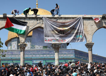 BELIA Palestin menggantung bendera dan kain rentang sempena Hari Al-Quds di hadapan Masjid al-Aqsa pada April lalu. - AFP