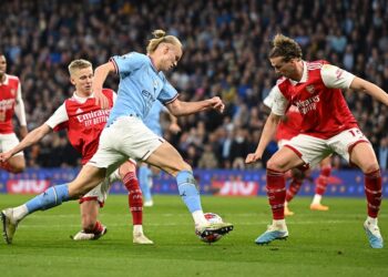 Penyerang Manchester City, Erling Haaland cuba untuk menggelecek barisan pertahanan Arsenal dalam aksi Liga Perdana Inggeris di Stadium Etihad awal pagi tadi. (Foto: AFP)
