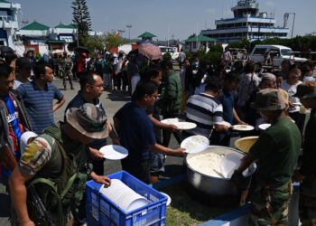 ORANG ramai beratur untuk mengambil makanan yang disediakan di Lapangan Terbang Imphal selepas melarikan diri akibat bimbang dengan rusuhan etnik yang berlaku. - AFP