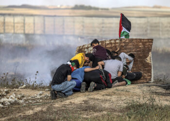 PENDUDUK Palestin berlindung ketika pasukan keselamatan Israel melepaskan tembakan peluru hidup di Gaza. - AFP