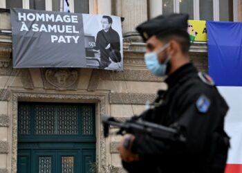 SEORANG anggota polis berdiri di depan bangunan Opera Comedie di Montpeller, Perancis yang menggantung poster Samuel Paty, kelmarin. – AFP