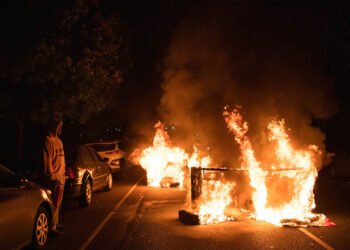 SEORANG lelaki melihat perabot yang dibakar penunjuk perasaan dalam satu protes di Philadelphia Barat, Amerika Syarikat. - AFP
