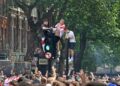 PARA penyokong skuad Three Lions memanjat lampu isyarat ketika berkumpul di London menjelang perlawanan akhir Euro 2020 melibatkan England dan Itali di Stadium Wembley.- AFP