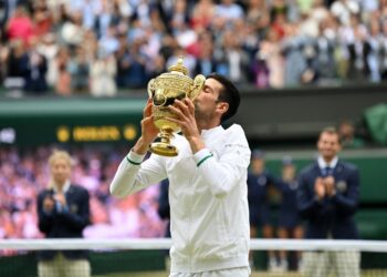 NOVAK DJOKOVIC mencium trofi kejuaraannya selepas menumbangkan Matteo Berrettini dalam perlawanan akhir di London, hari ini.- AFP