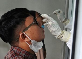 PETUGAS kesihatan mengambil ujian calitan Covid-19 di Banda Aceh, baru-baru ini. – AFP