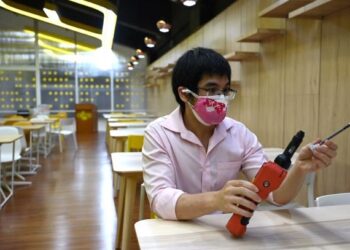 CHADIN Kulsing memeriksa peralatan yang digunakan untuk mengesan Covid-19 melalui peluh ketiak. - AFP