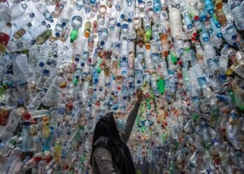 AKTIVIS alam sekitar menyusun botol yang dikutip dari sungai di Gresik untuk pameran plastik di Jawa Timur.– AFP