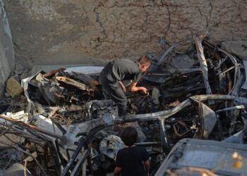 AHLI keluarga Zemerai Ahmadi memeriksa bangkai kenderaan yang musnah dalam serangan dron di Kabul pada bulan lalu. – AFP