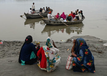 BEBERAPA wanita duduk di tepi Sungai Ganges sambil menunggu bot untuk menyeberangi sungai itu di Kanpur, India. - AFP