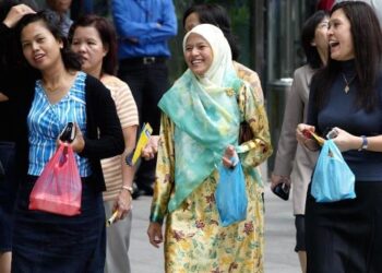 PEKERJA wanita Melayu Singapura ketika waktu rehat makan tengah hari di Singapura. - AFP
