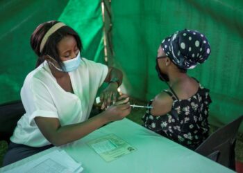 SEORANG penduduk menerima suntikan vaksin di sebuah pusat vaksinasi di Dewan Kopanong di Soweto, Johnnesburg, Afrika Selatan. - AFP 