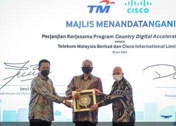 IMRI Mokhtar (kiri) menyampaikan cenderamata kepada Presiden Cisco Asia Pasifik, Jepun dan China, Dave West sambil disaksikan oleh Annuar Musa di Putrajaya, hari ini. - UTUSAN/FAIZ ALIF AHMAD ZUBIR