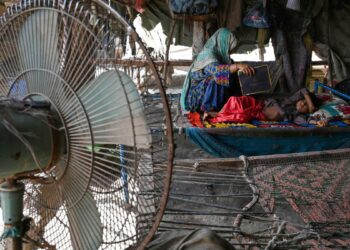 SEORANG wanita mengipas anaknya yang kepanasan di tengah-tengah suhu yang semakin meningkat di Jacobabad di Pakistan. - AFP 