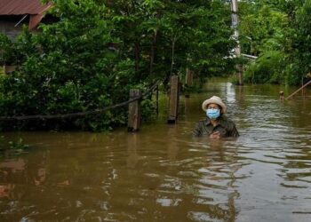 PENDUDUK meredah banjir di depan rumahnya di wilayah Ayutthaya baru-baru ini. – AFP