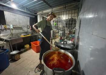 MUHAMMAD Hakim Shafiai mengacau gulai ikan aya untuk nasi dagang yang ditempah pelanggan pada Hari Raya Aidilfitri ketika ditemui di rumahnya di Taman Mas, Bukit Payung di Marang, semalam. - PUQTRA HAIRRY ROSLI