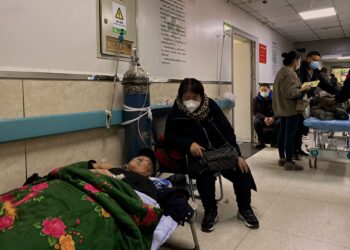 PESAKIT Covid-19 terpaksa berbaring atas katil di kawasan pejalan kaki di Hospital Tangshan Gongren, China.-AFP
