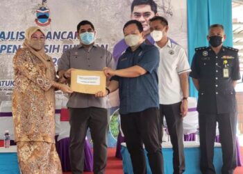 SHAHELMEY Yahya (dua kiri) menyaksikan penyerahan borang pertandingan kebersihan kampung di Putatan hari ini.