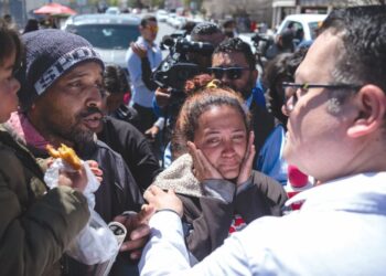 MIGRAN mengadu kepada pelawat Suruhanjaya Hak Asasi Manusia Mexico, Raul Arturo Ramirez (kanan) di luar pusat tahanan imigresen di mana 38 pendatang maut semasa kebakaran di Ciudad Juarez, negeri Chihuahua, Mexico pada 29 Mac lalu.-AFP
