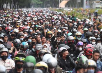 PENUNGGANG motosikal menunggu giliran sebelum memasuki Pelabuhan Merak di Banten yang dipenuhi puluhan ribu pengguna.-ANTARAFOTO
