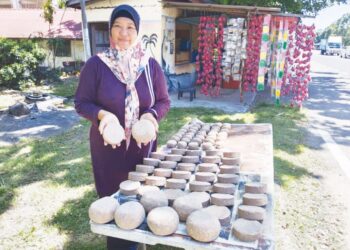 MASNAH Abd. Majid menunjukkan belacan yang dijual di kedainya di Klebang, Melaka.