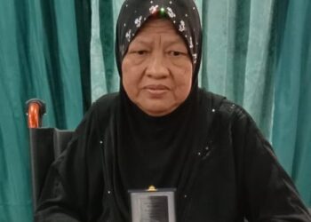 ROSLINA Abdul Rahman bersama pingat PJM yang diterima bagi pihak arwah suaminya pada majlis penganugerahan pingat tersebut di KD Pelandok, Pangkalan TLDM Lumut, Perak. - UTUSAN/SHAMSUL KAMAL AMARUDIN