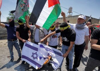 PENUNJUK perasaan mengibarkan bendera Palestin ketika demonstrasi di perkampungan Kfar Qaddum berhampiran penempatan Kedumim di Tebing Barat pada Mei tahun lalu.-AFP