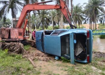 ANGGOTA Bomba mengeluarkan mayat mangsa yang dihanyutkan arus deras di jambatan Sungai Memanjang, Beluran, Sandakan semalam.-IHSAN BOMBA