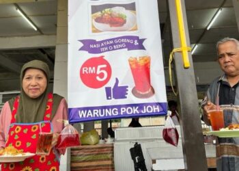 HAMZAH Daud (kanan) dan isterinya, Siti Fatimah Omar bersama Menu Rahmah yang disediakan di kedai makan mereka di Bandar Lama, Gua Musang, Kelantan. - FOTO/AIMUNI TUAN LAH
