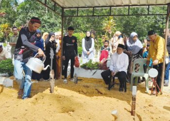 JOHARI Mohd. Barjol menyiram air mawar ke atas pusara dua anaknya yang dikebumikan dalam satu liang 
lahad di Tanah Perkuburan Islam Batu Ampat, Jalan Lombong, Kota Tinggi, semalam.