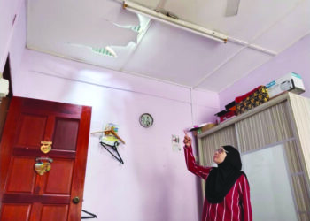 NORITA Salleh menunjukkan keadaan siling rumah kakaknya yang rosak akibat dibadai ribut di Taman Baiduri, Alor Gajah, Melaka. – UTUSAN/MUHAMMAD SHAHIZAM TAZALI