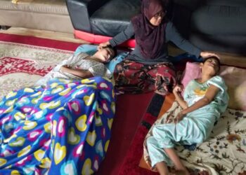 UMI KALSUM Ree menguruskan keperluan Norjan Ahmad  (kiri) serta  Ainul Nadiah Ree, 38, masing-masing mengalami Cerebral Plasy (CP) di perkampungan nelayan Kuala Juru, Butterworth, Pulau Pinang baru-baru ini.