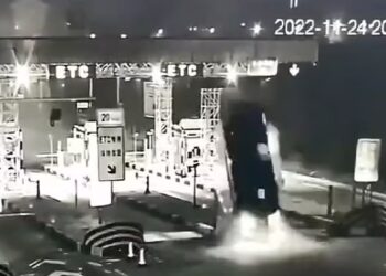 TANGKAP layar video menunjukkan sebuah kereta memecut ke arah penghadang di Stesen Tol Shihe di China sebelum terbalik.-AGENSI