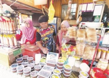 MAS Nawi Yusof bersama dua isterinya, Siti Nor Aisyah Saawal (kiri) dan Marzurah Abdul Rahman menguruskan kedai berhampiran Hutan Rekreasi Sungai Udang, Melaka. – UTUSAN/AMRAN MULUP