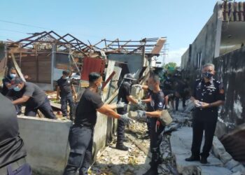 ANGGOTA PSP Unit 5 Ipoh membantu membersihkan kawasan rumah terjejas ribut dan puting beliung di Kampung Tawas di  Ipoh hari ini. - UTUSAN