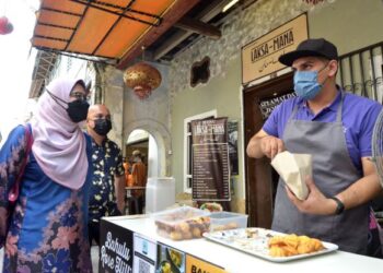 NOLEE Ashilin Mohd. Radzi (kiri) beramah mesra dengan seorang peniaga ketika melawat Concubine Lane di Ipoh hari ini. - UTUSAN/ZULFACHRI ZULKIFLI