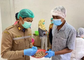 ANGGOTA Badan Kuarantin Pertanian memeriksa kualiti buah pala di sebuah kilang di Maluku.-AGENSI