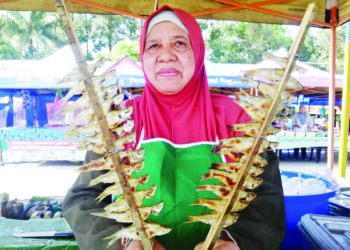 SITI Fauziah Abdul Kadir menunjukkan ikan seluang panggang yang dijual di Bazar Ramadan Kuala Ping, Hulu Terengganu, Terengganu. – UTUSAN/NOOR HAYATI MAMAT