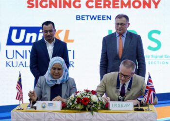 ASYRAF Wajdi Dusuki (berdiri kiri) dan Charles Hay menyaksikan pemeteraian kerjasama antara Universiti Kuala Lumpur dengan Institution of Railway Signal Engineers (IRSE UK) di Kuala Lumpur, hari ini. - UTUSAN/FAUZI BAHARUDIN