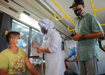 ROSOL Wahid (kanan) melihat proses suntikan vaksin Covid-19 dalam Program Mobilisasi Vaksin Komuniti (Movak) di Sekolah Kebangsaan Felda Bukit Bading di Hulu Terengganu, hari ini. -PUQTRA HAIRRY ROSLI