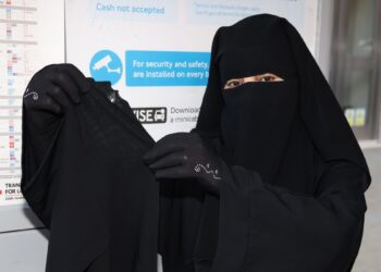 SOUAD Mohammed memegang niqab yang sering dipakainya biarpun mendapat kejian malah cacian masyarakat. – AGENSI